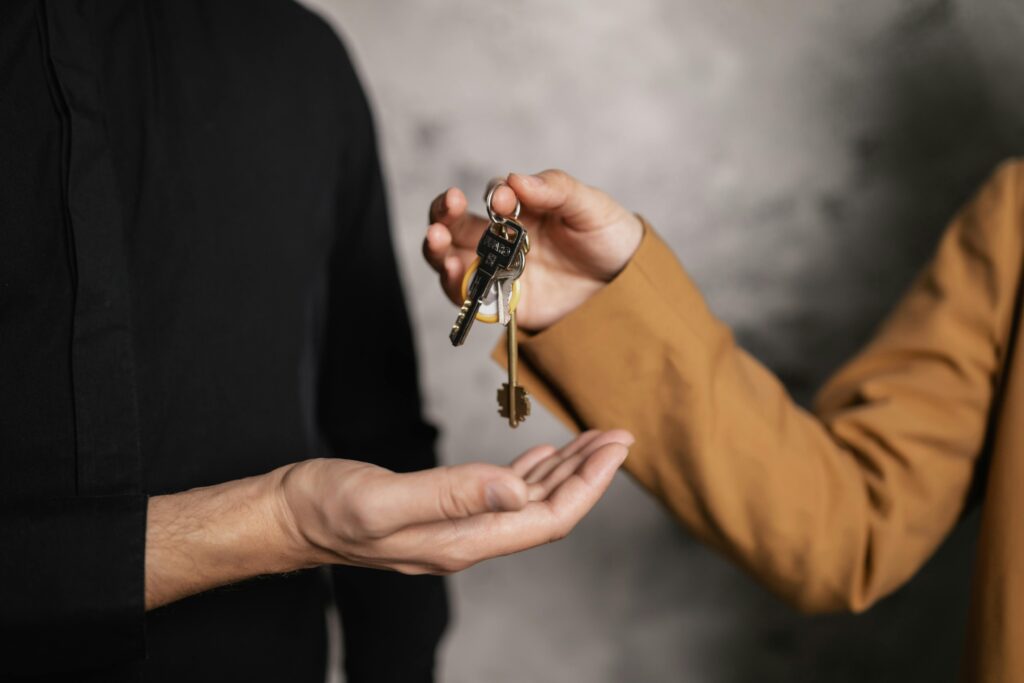 Closely cropped in photo of a hand passing keys to a hand of a new homebuyer.